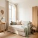 Petit studio parisien lumineux de 18 m² avec canapé-lit beige, table murale rabattable en chêne clair, rangements verticaux et décoration scandinave élégante.